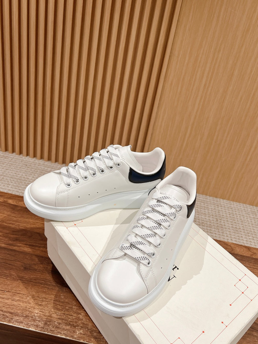 White leather sneakers with navy-trim collar and thick white rubber sole