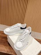 White leather sneakers with navy-trim collar and thick white rubber sole