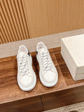 Pair of white leather lace-up sneakers with navy heel accents on display
