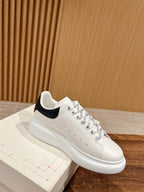 White low-top sneaker with navy collar trim and padded sole