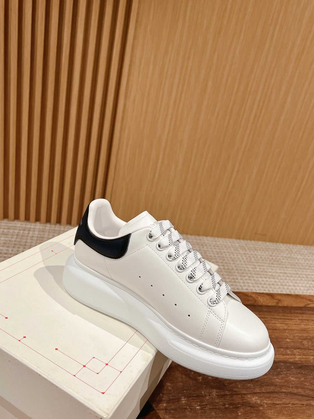 White low-top sneaker with navy collar trim and padded sole