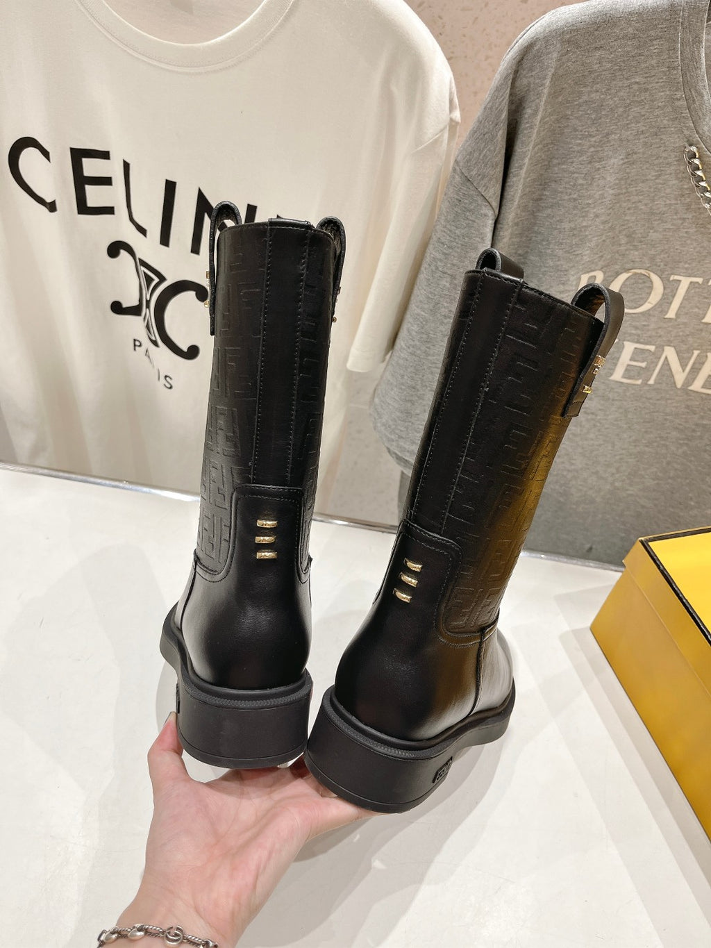 Black mid-calf pull-on boots shown from the back with low stacked heels