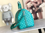 Teal monogram mini duffel bag with curved handles and crossbody strap