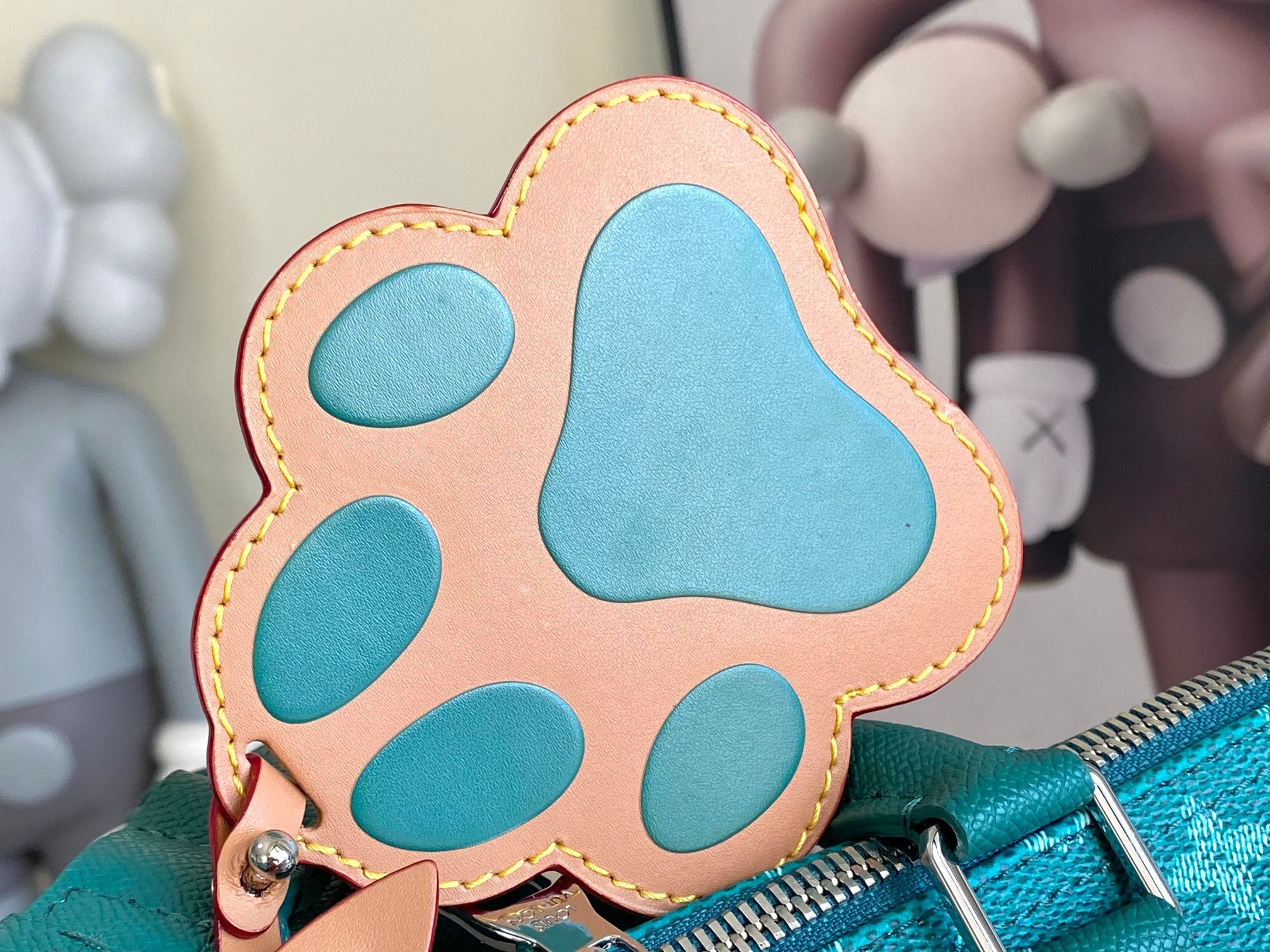Teal and tan bear paw applique with stitched edges on teal monogram bag