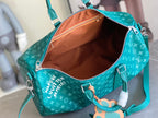 Teal monogram duffel bag open interior with orange lining and zipper pocket
