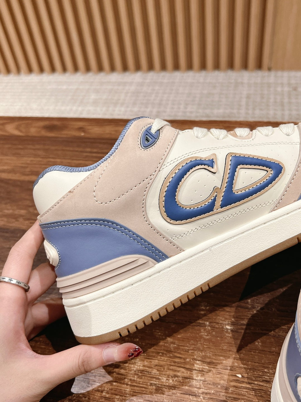 Dior unisex sneakers, side profile with large blue CD logo patch.