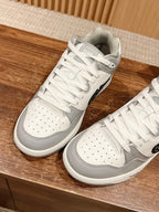 White and gray low-top sneakers with perforated toe and white laces