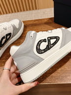 White and gray low-top sneakers with large black C-D logo on side, close-up