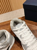 White and gray low-top sneakers with Dior detail on tongue, close angle