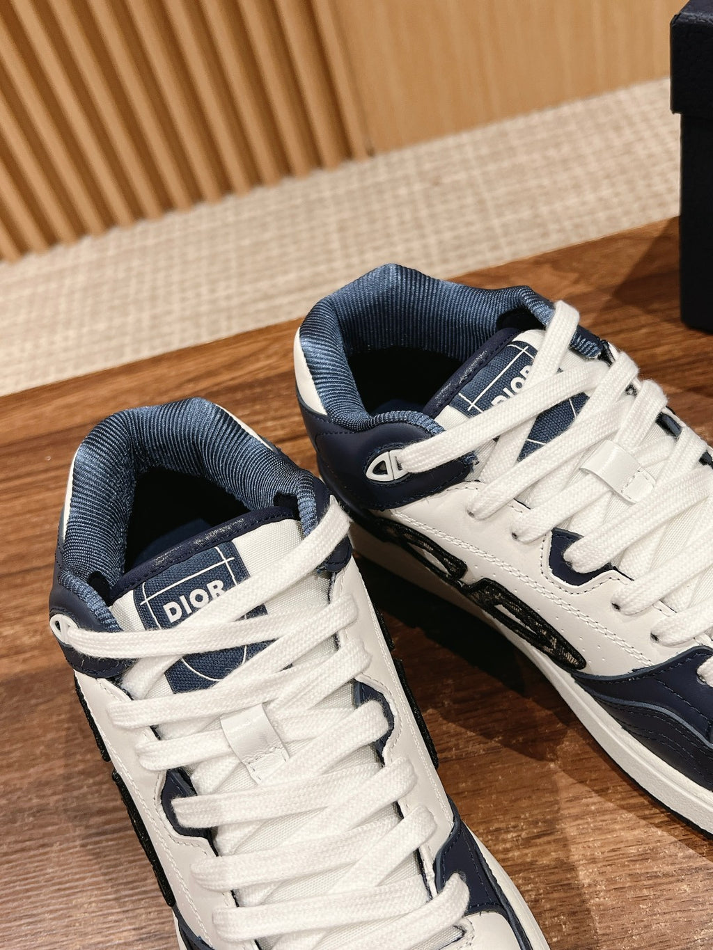 White-and-navy low-top sneakers with lace-up ties and Dior label on tongues