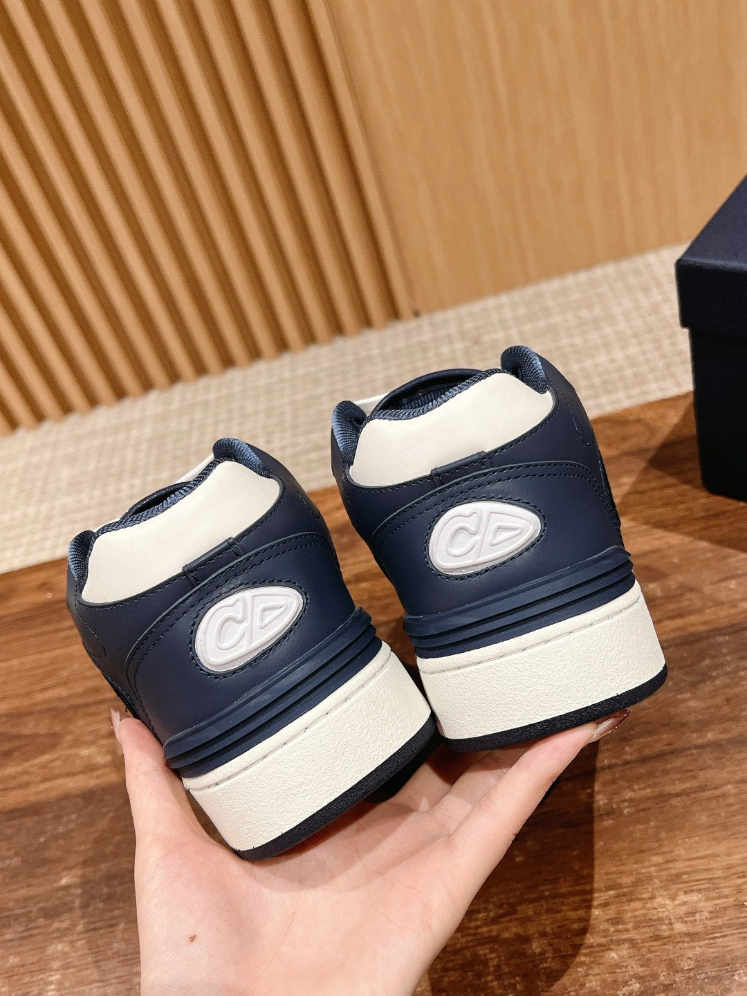 Pair of navy low-top sneakers with white midsoles and rear logo patch