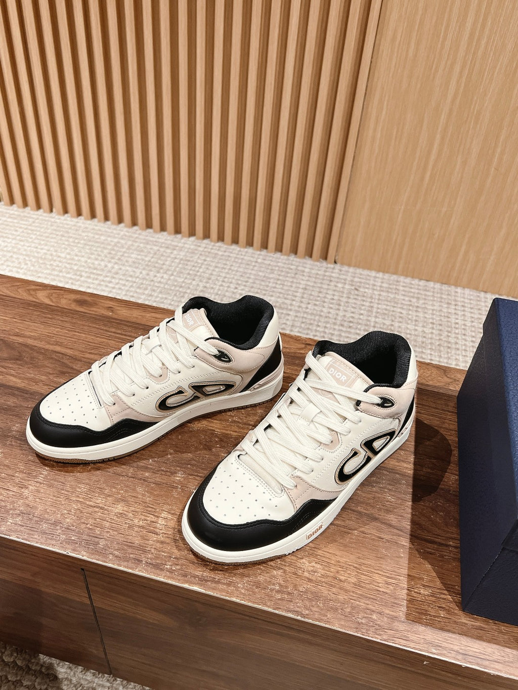 Cream and black lace-up unisex sneakers with bold logo detail on side