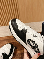 Dior unisex sneakers close-up: white laces with black panel and textured side emblem