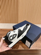 Dior unisex sneakers with black leather, white eyelets, and DIOR strap detail