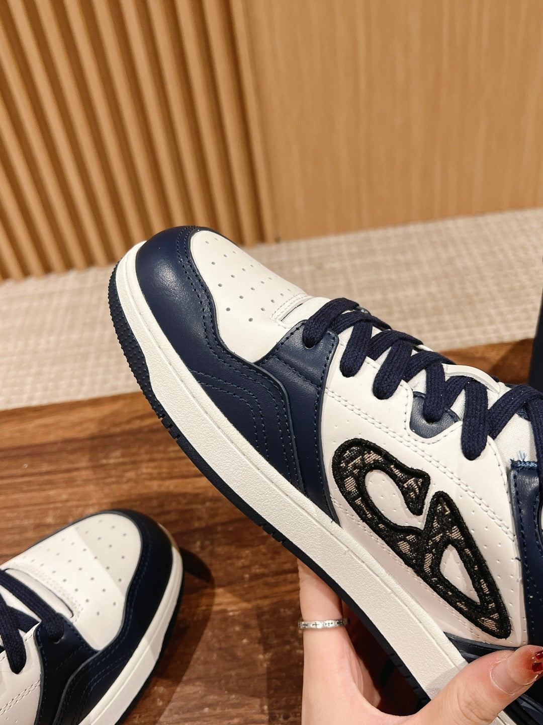 Close-up of navy and white sneaker with textured side emblem