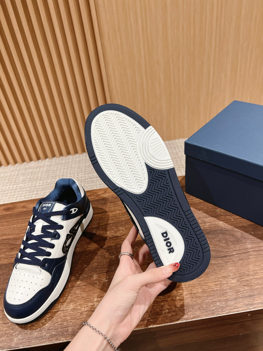 Low-top sneakers showing soles with Dior logo and tread pattern