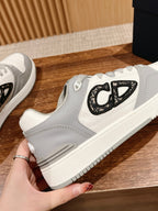 Dior unisex sneakers close-up: white and gray uppers with black embroidered logo
