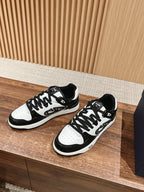 Black and white Dior lace-up sneakers with white toe cap and patterned panel details