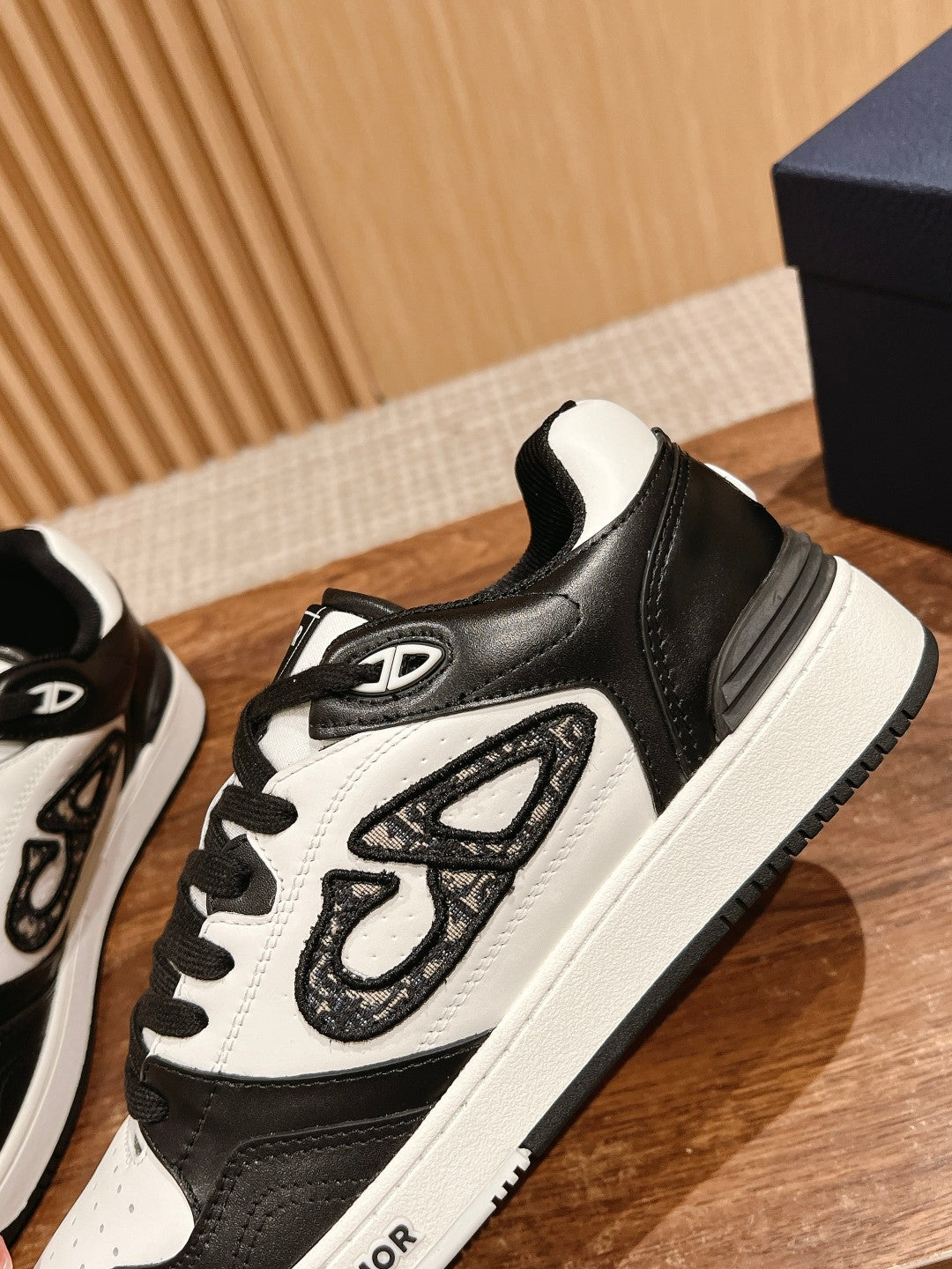 Black and white Dior lace-up sneakers with textured side panel and white midsole