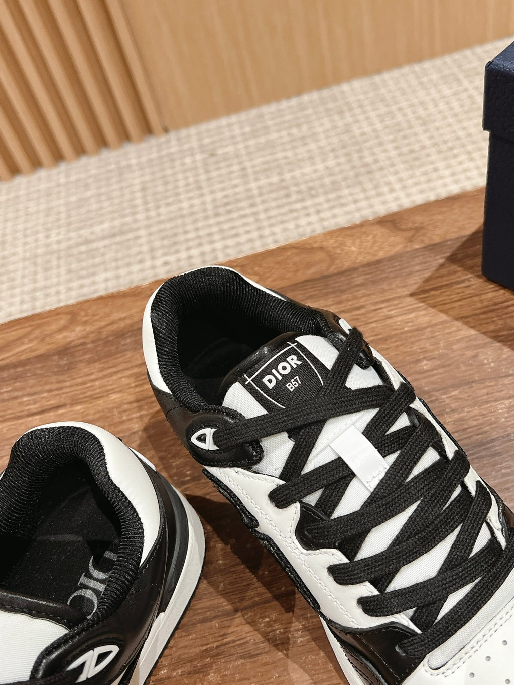 Black and white Dior sneakers with black tongue label and crisscross lace pattern