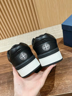 Black low-top sneakers back view with white sole and circular heel logo
