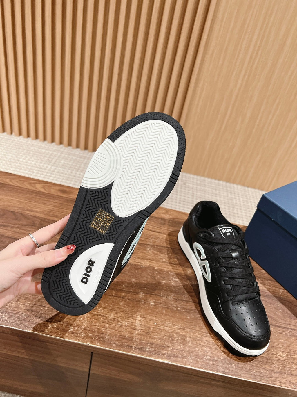 Black sneakers showing tread and Dior insoles, white sole, lace-up design