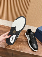 Black sneakers showing tread and Dior insoles, white sole, lace-up design