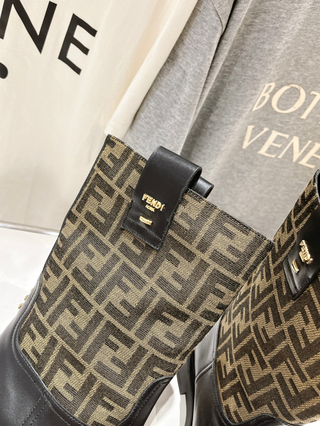 Fendi FF-logo boots, black ankle panel with gold-tone stud buckle detail.