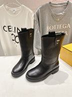 Black mid-calf pull-on boots with square-toe silhouette and gold accents