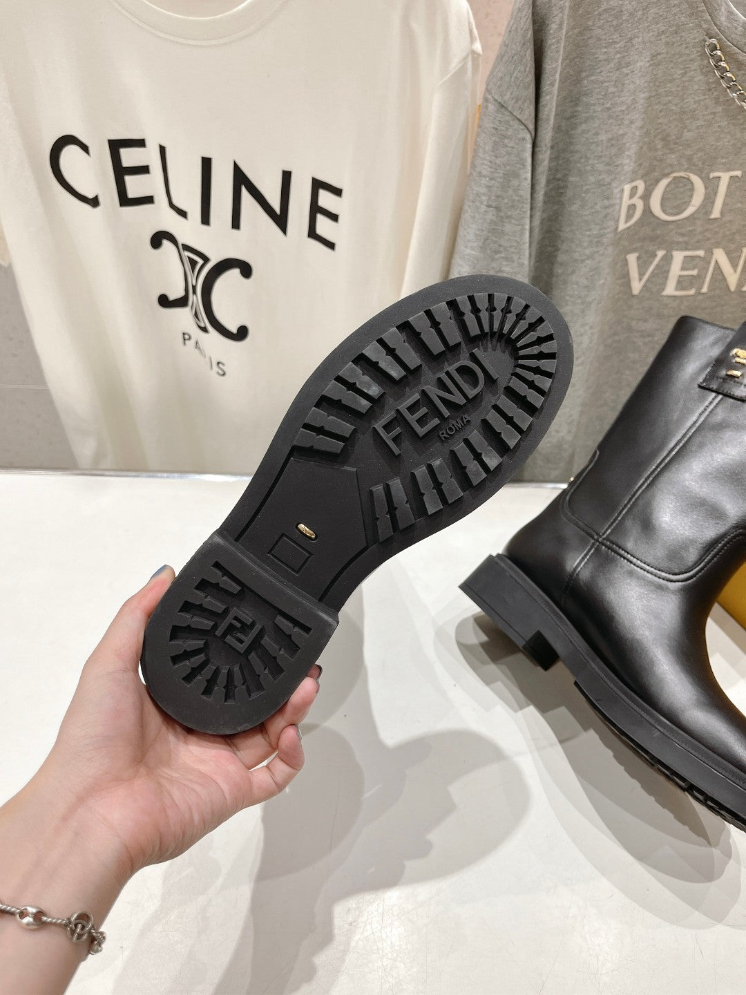 Fendi women’s boot soles, black tread with logo, plus side view of leather boot.
