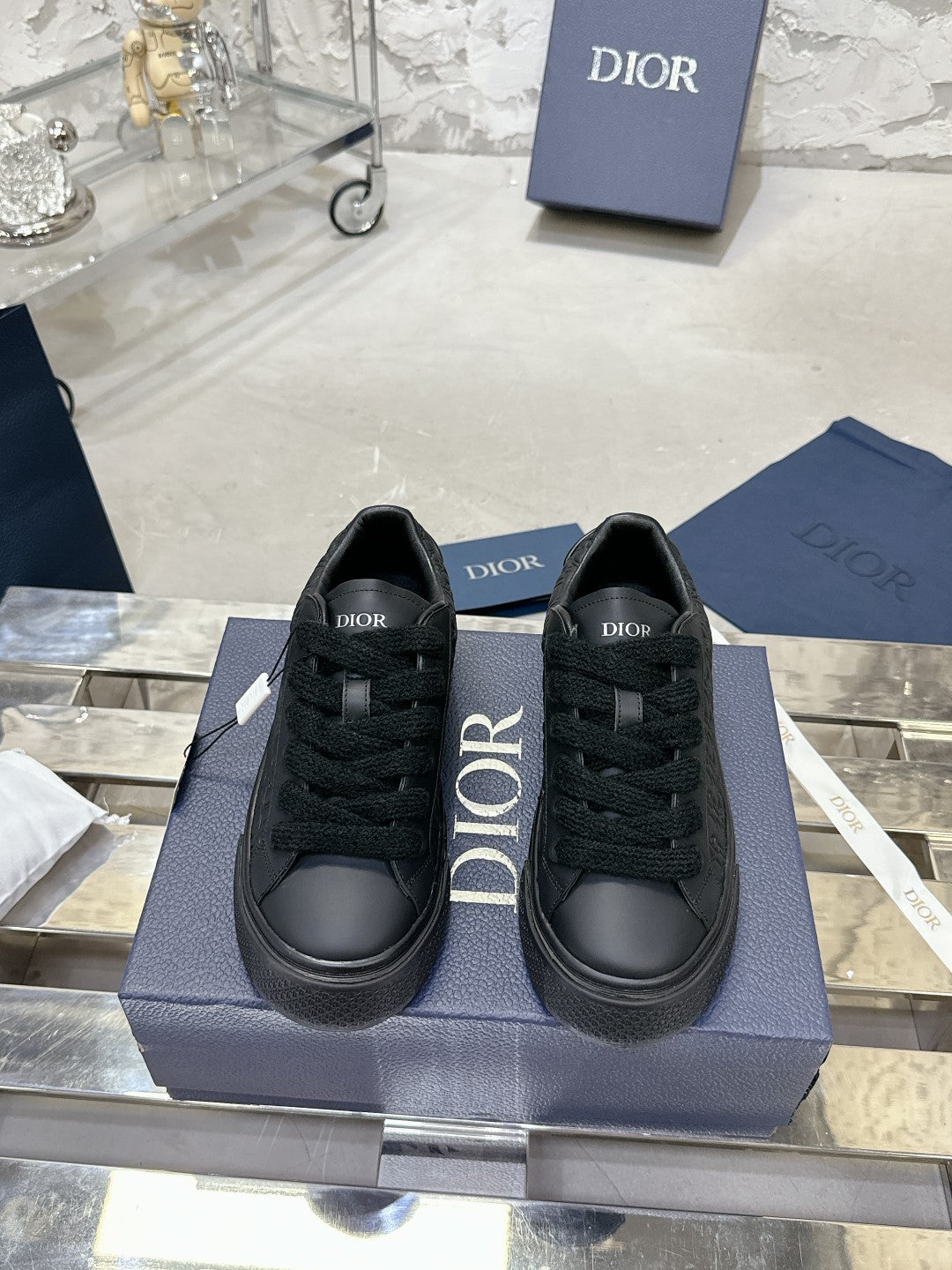 Black lace-up sneakers with Dior logo branding on tongue and sides, on box