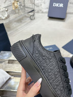 Black lace-up low-top sneaker with embossed pattern and cushioned rubber sole