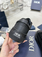 Black sneaker heel with Dior logo patch and thick rubber sole, near box