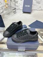 Black lace-up sneakers with embossed Dior monogram, shown on blue box