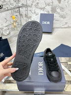 Black sneaker outsole with tread pattern, Dior logo on side near box