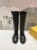 Black knee-high boots with side pull tabs and rounded toe, flat sole.