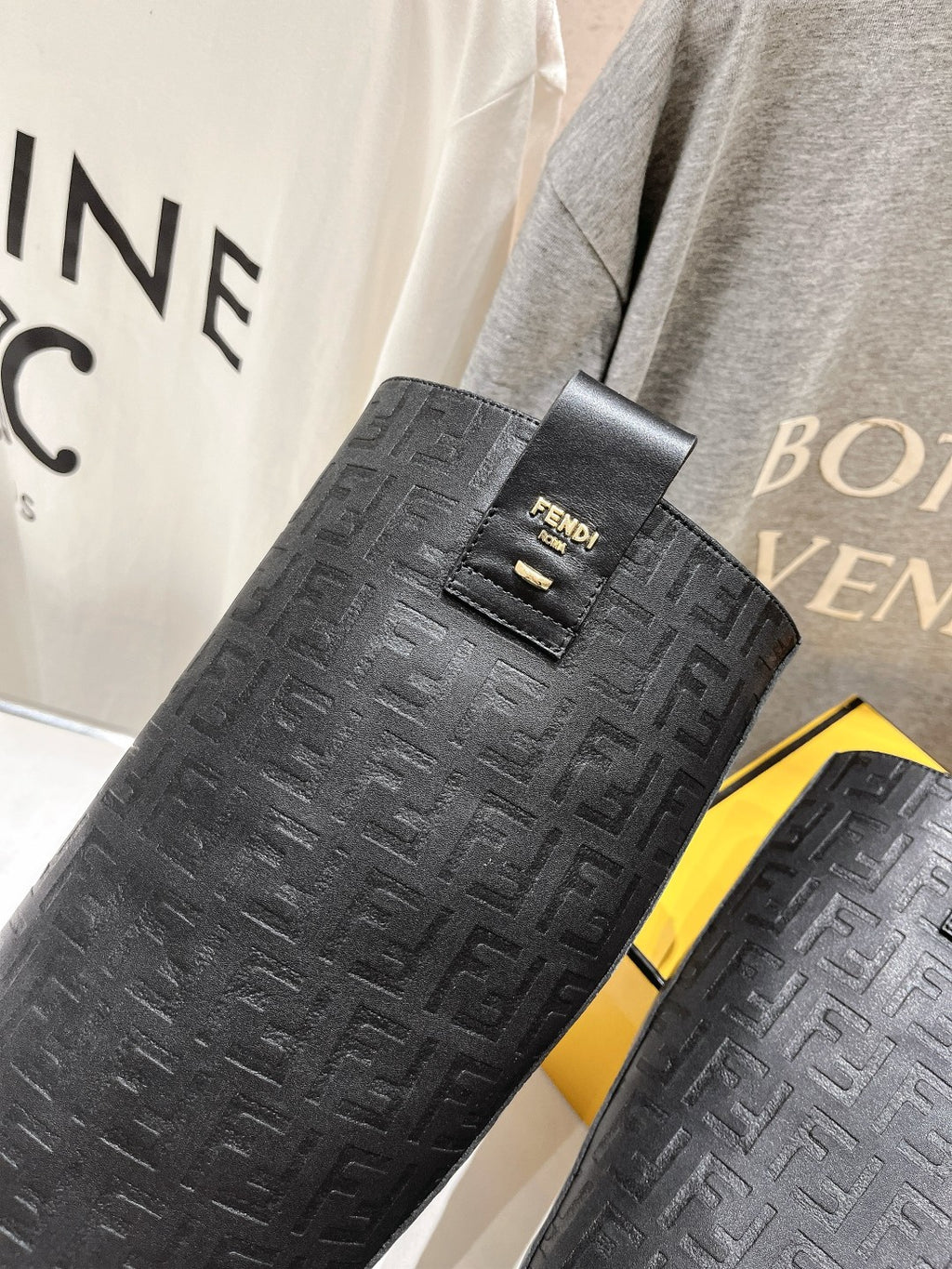 Black textured knee-high boots with Fendi-branded strap and buckle detail.