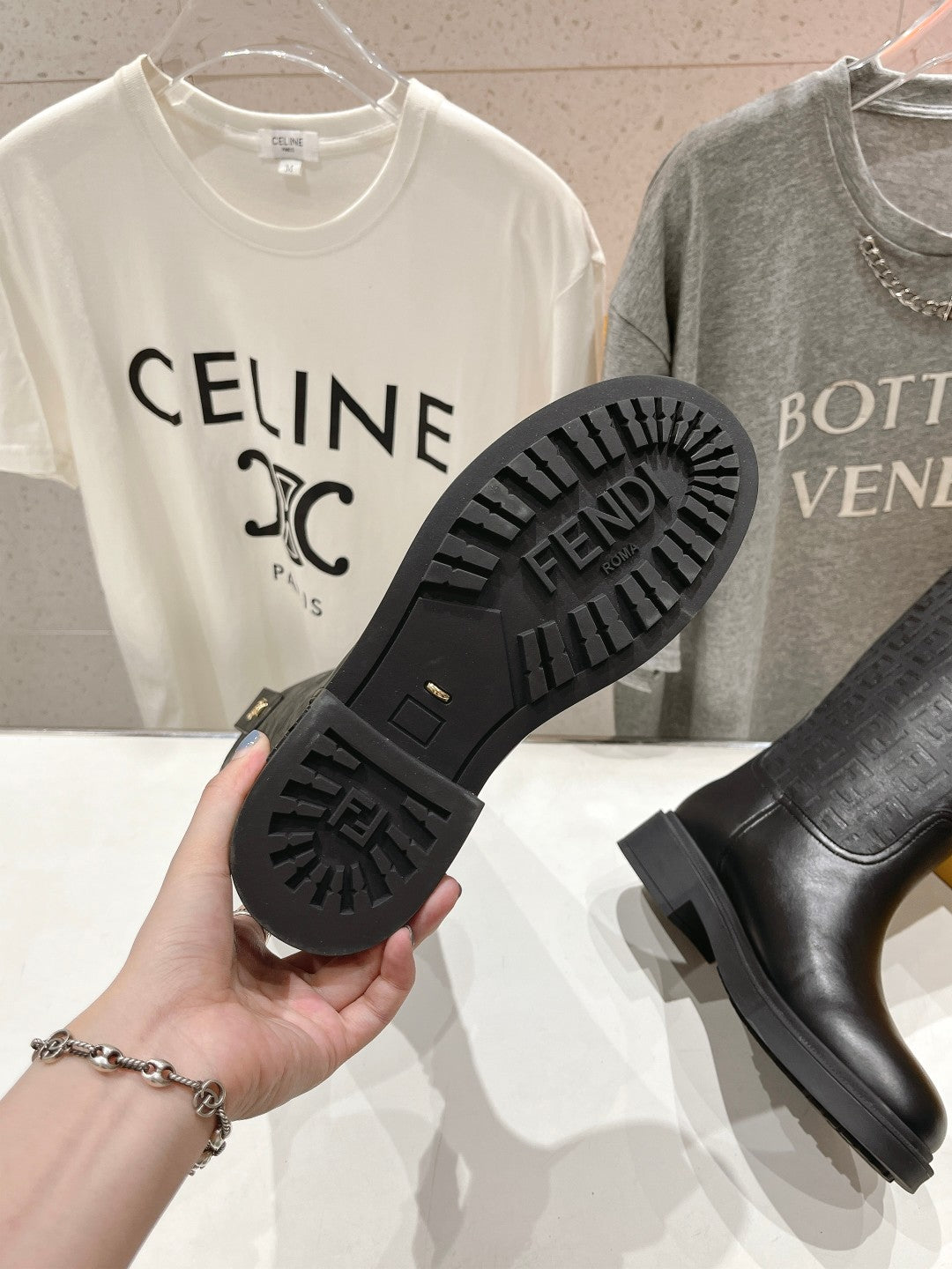 Black knee-high boots with treaded rubber outsole and side pull tabs.