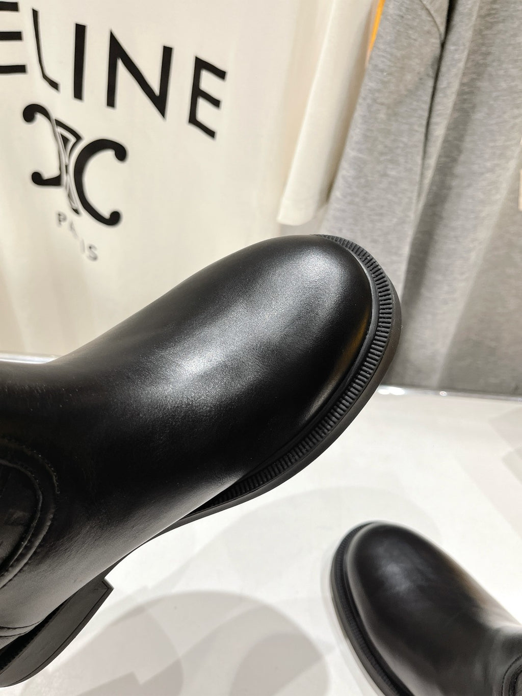 Black knee-high boot with smooth leather finish and ribbed welt edge.