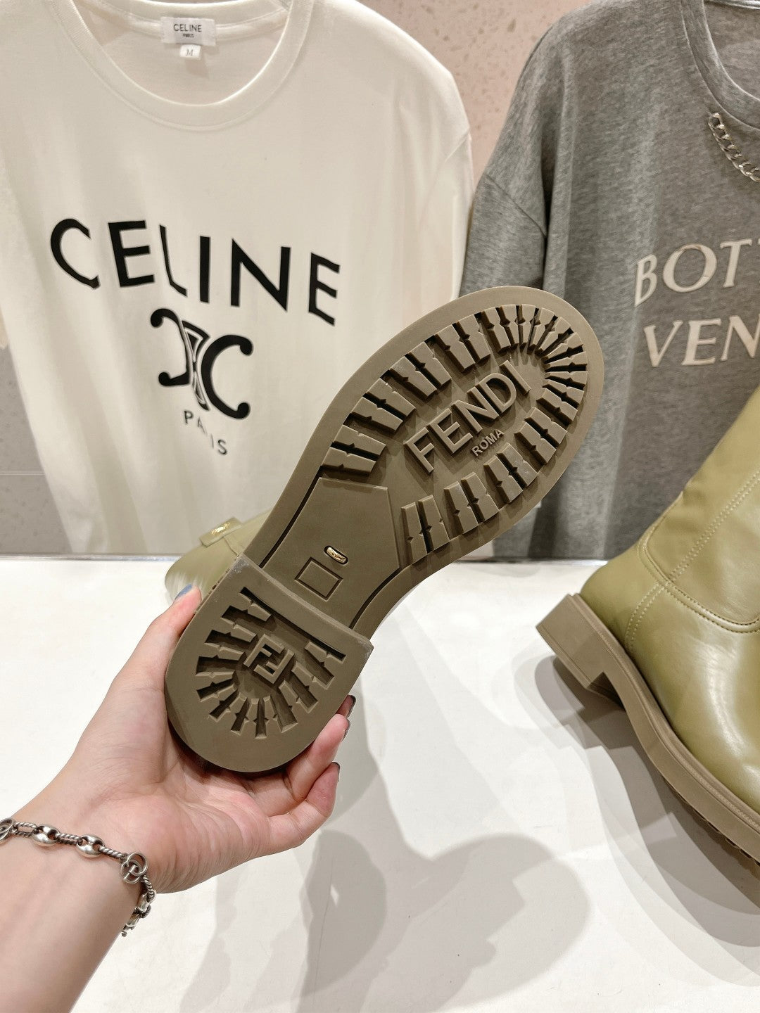 Boot sole underside with FENDI logo and tread pattern on olive green outsole.