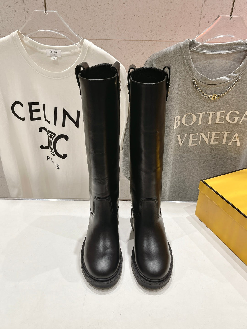 Pair of black knee-high leather boots on display with pull tabs