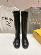 Pair of black knee-high leather boots on display with pull tabs