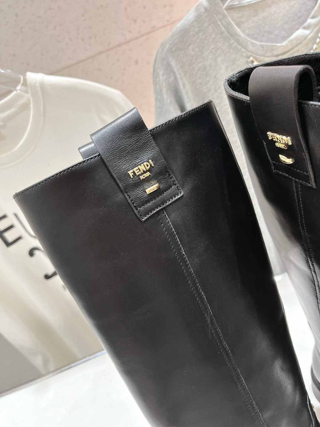 Black leather knee-high boot upper with FENDI logo patch and side pull opening