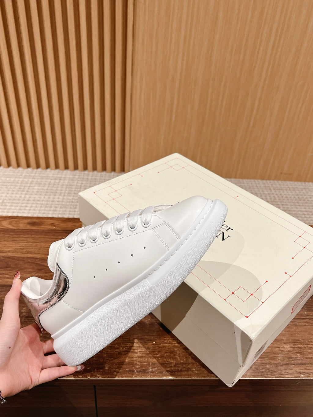White lace-up sneakers with perforated toe and padded sole