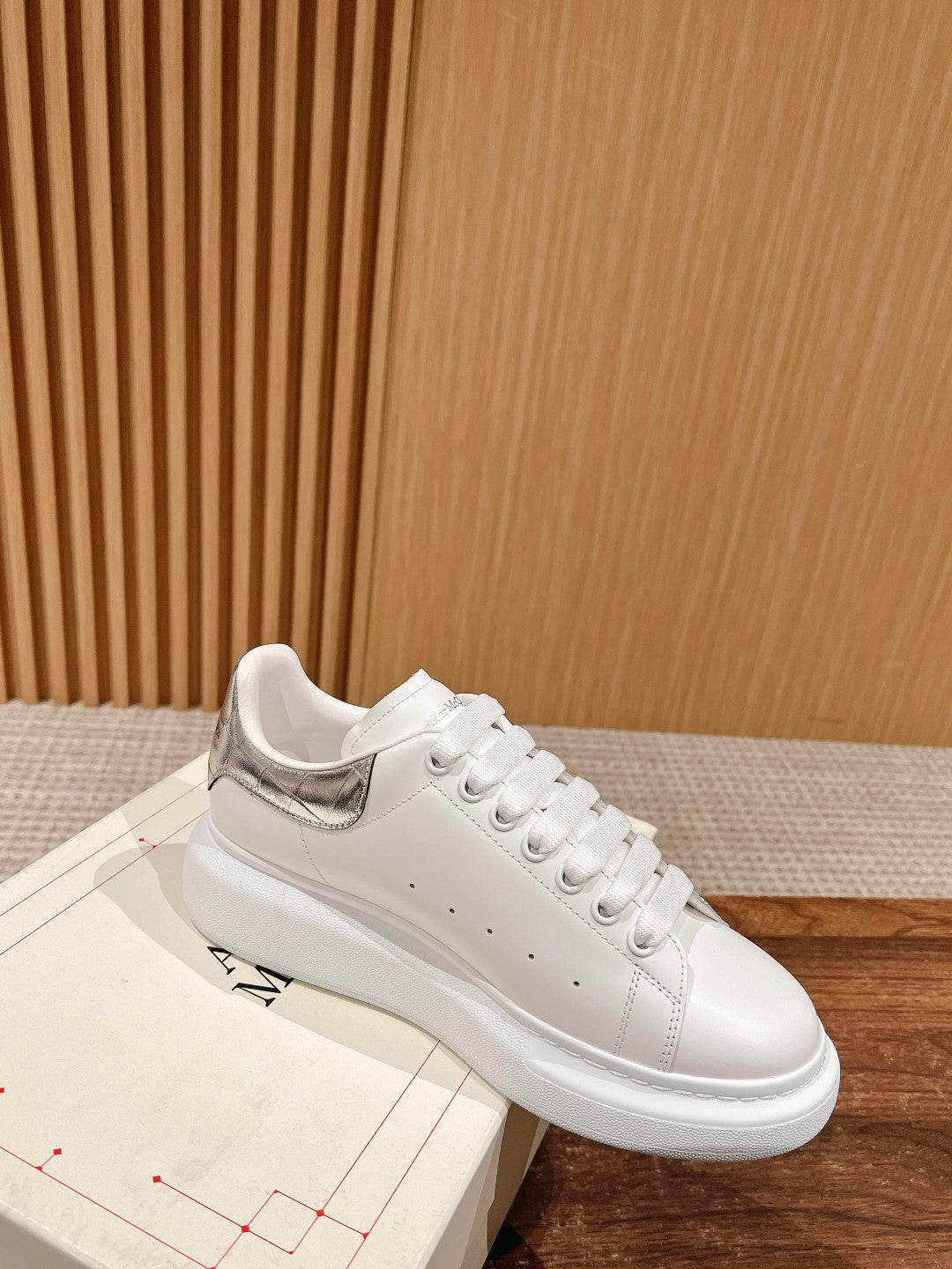 White leather lace-up sneakers with silver heel accent and stitched detailing