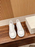 Pair of white low-top lace-up sneakers with smooth leather upper