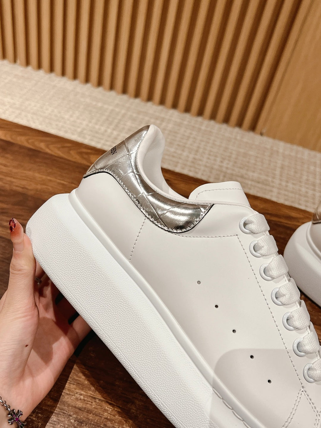 White leather sneakers with metallic silver heel insert and lace-up front