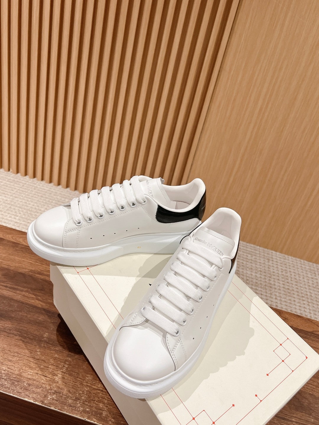 White low-top sneakers with black heel accent and padded tongue