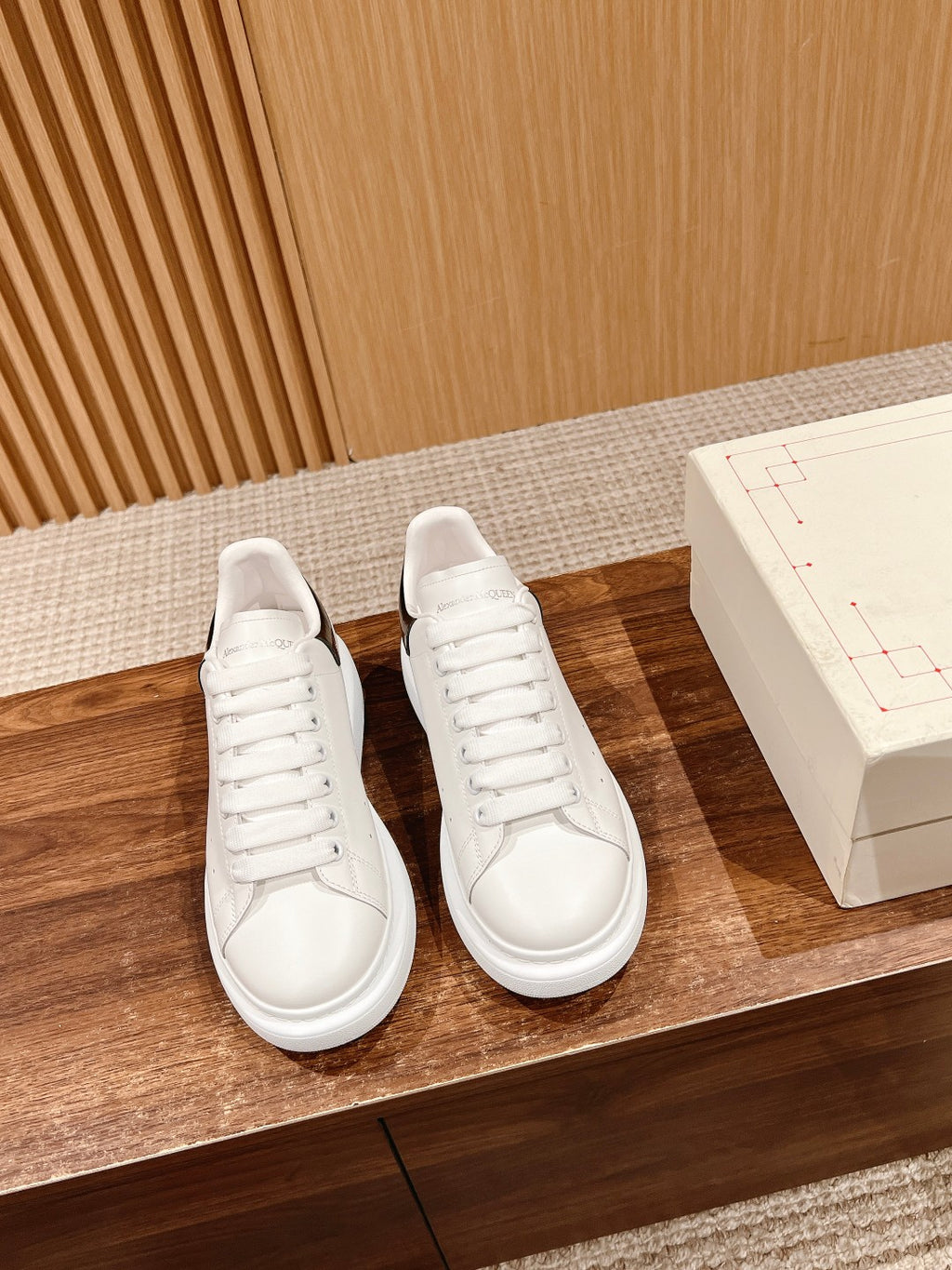 Pair of white low-top sneakers with lace-up front and white rubber sole