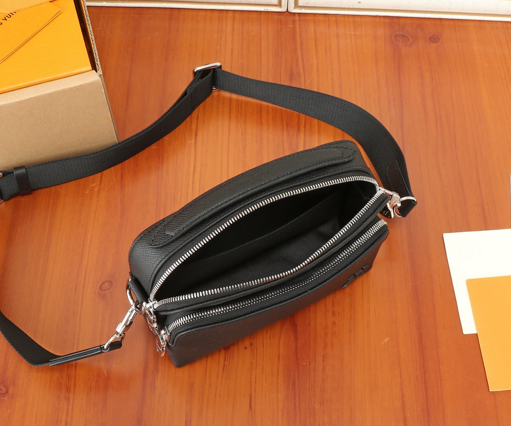 Black crossbody bag with long strap and double-zip front pocket
